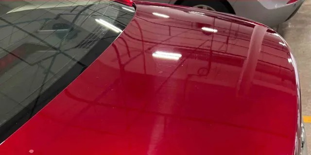 Before paint correction — red vehicle panel showing swirls and haze under studio lighting at Studio One Protection in Tri-Cities, WA.